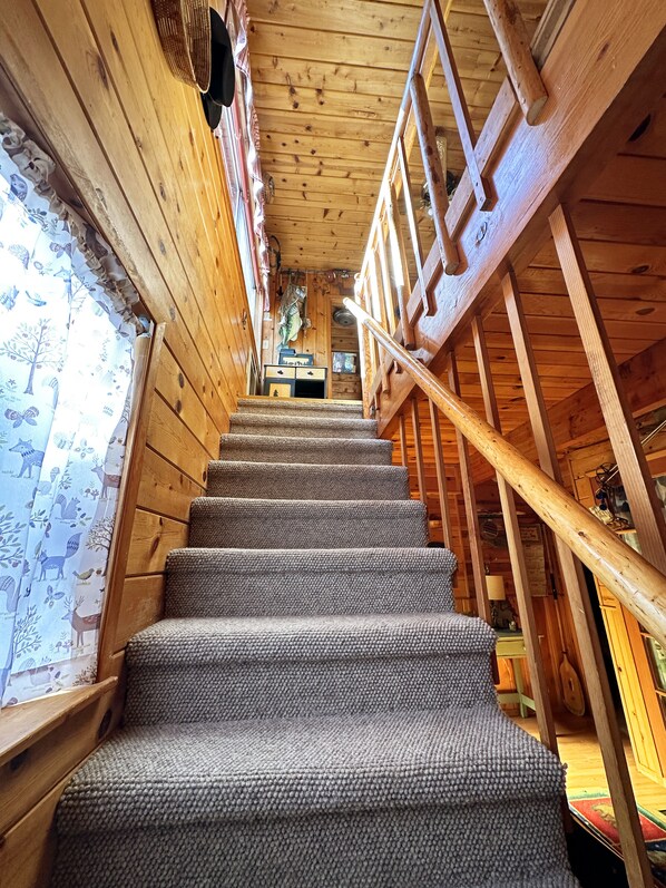 A wooden staircase with a handrail, leading to a room with a window and a door. - Autumn is beautiful in the mountains.  We welcome you, and we're pet-friendly! (Pine Mountain Club)