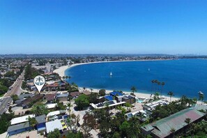 Une ville côtière avec une plage, des bâtiments et un ciel bleu dégagé.