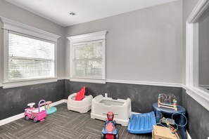 Cozy space with a window seat, play area, and small table.