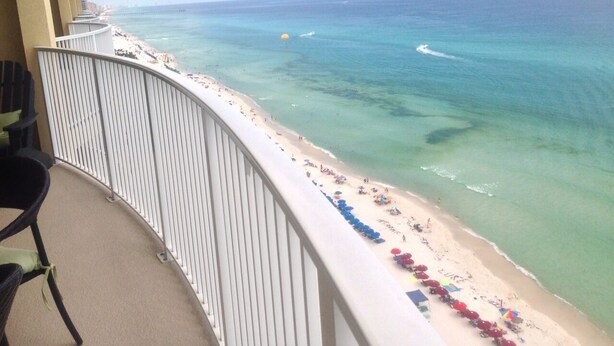 Un balcon avec vue sur une plage et l’océan.