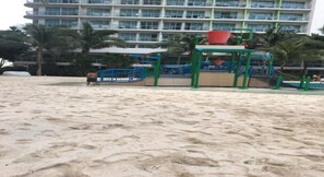 Kids can play on the beachside playground with a bucket and slide.