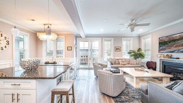 Un espacio habitable amplio con una isla de cocina, una mesa de comedor y una chimenea.