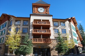 A multi-story building with a prominent clock tower, balconies, and a stone facade. - Largest 1 Br Condo With Den, Quiet Top Floor End Unit, Sleeps 6 (Solitude)