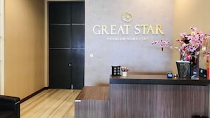 A reception desk with a sign that reads "GREAT STAR PREMIUM-HOMESTAY". - Great Star Premium Homestay (Malang)
