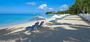 Di pantai dan kursi berjemur