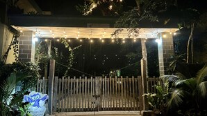 A gated entrance with a wooden fence, string lights, and a sign for 'HOKKMAH Adventure'. - Hokhmah Heart Hotel (Puerto Morelos)