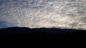 Un paisaje con una cadena montañosa y un cielo cubierto de nubes.