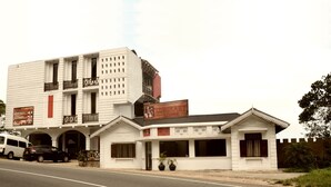 Un edificio de dos pisos con un letrero que indica restaurante y otro que anuncia habitaciones.