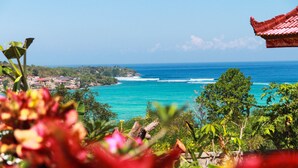 A coastal view with a clear sky, turquoise sea, and a distant shoreline with buildings. - Bukit Permata Lembongan (Lembongan Island)