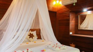 A wooden room with a four-poster bed, a mirror, and a wooden shelf. - Bukit Permata Lembongan (Lembongan Island)