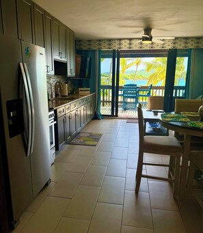 Cocina equipada con refrigerador, microondas y estufa.  Comedor con mesa y sillas.