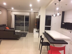 Relax in this stylish living space with a sofa, dining table, and balcony access.