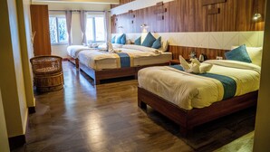 Ett hotellrum med två sängar, ett trägolv, en flätad stol och utsikt över omgivningarna.