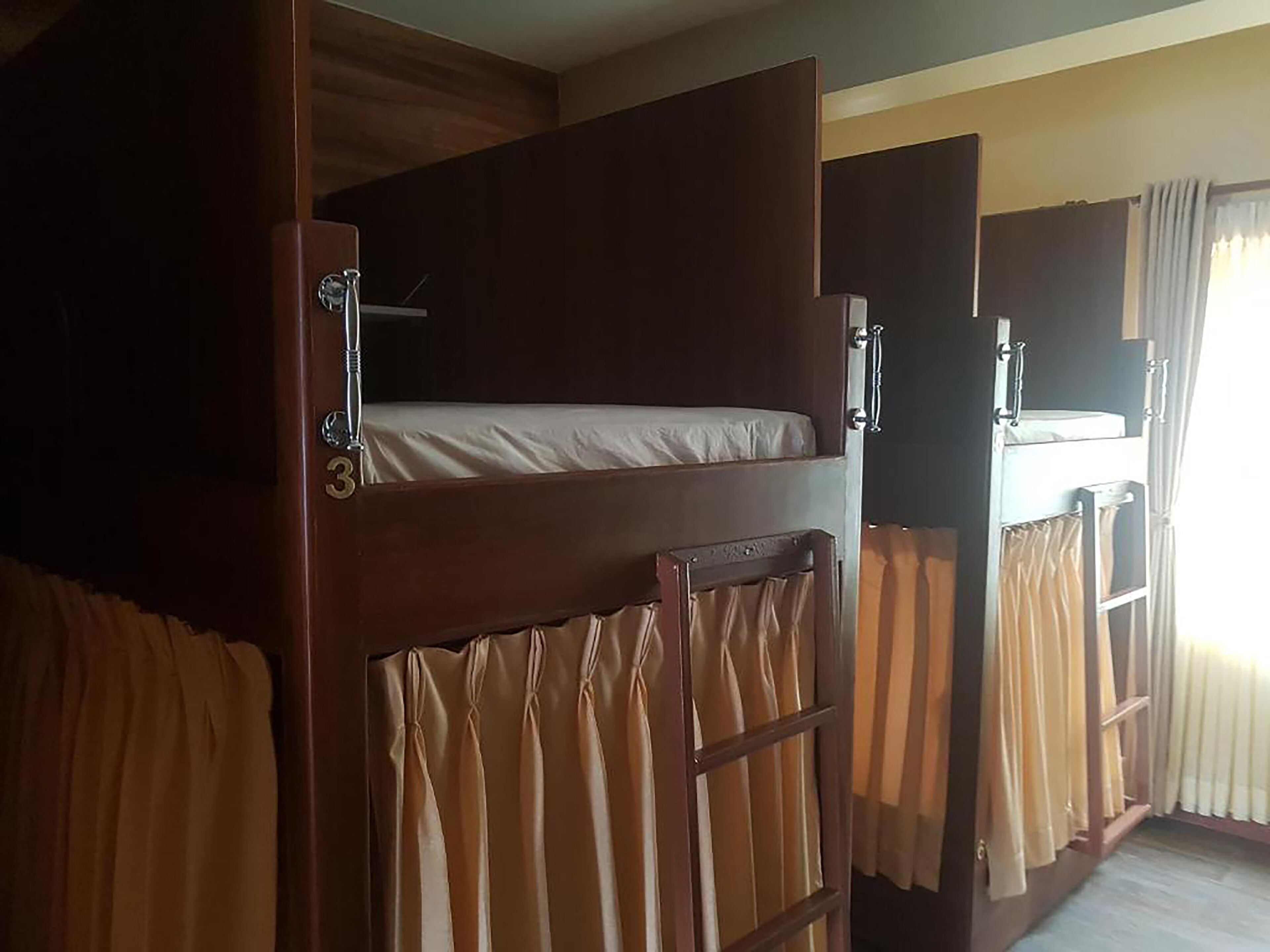 A bunk bed room with curtains and a window.