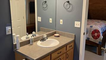 Een bad/douchecombinatie, een haardroger, handdoeken, zeep