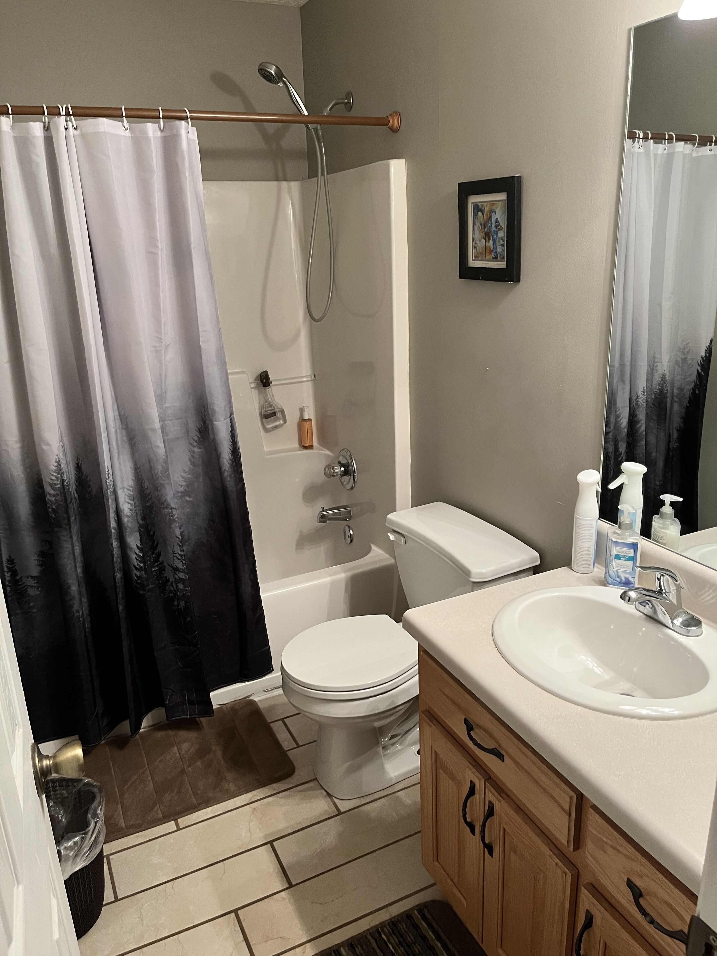 A bathroom with a toilet, bathtub, shower, and sink.