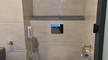 Un baño pequeño y moderno con inodoro, secador de manos y dispensador de toallas de papel.