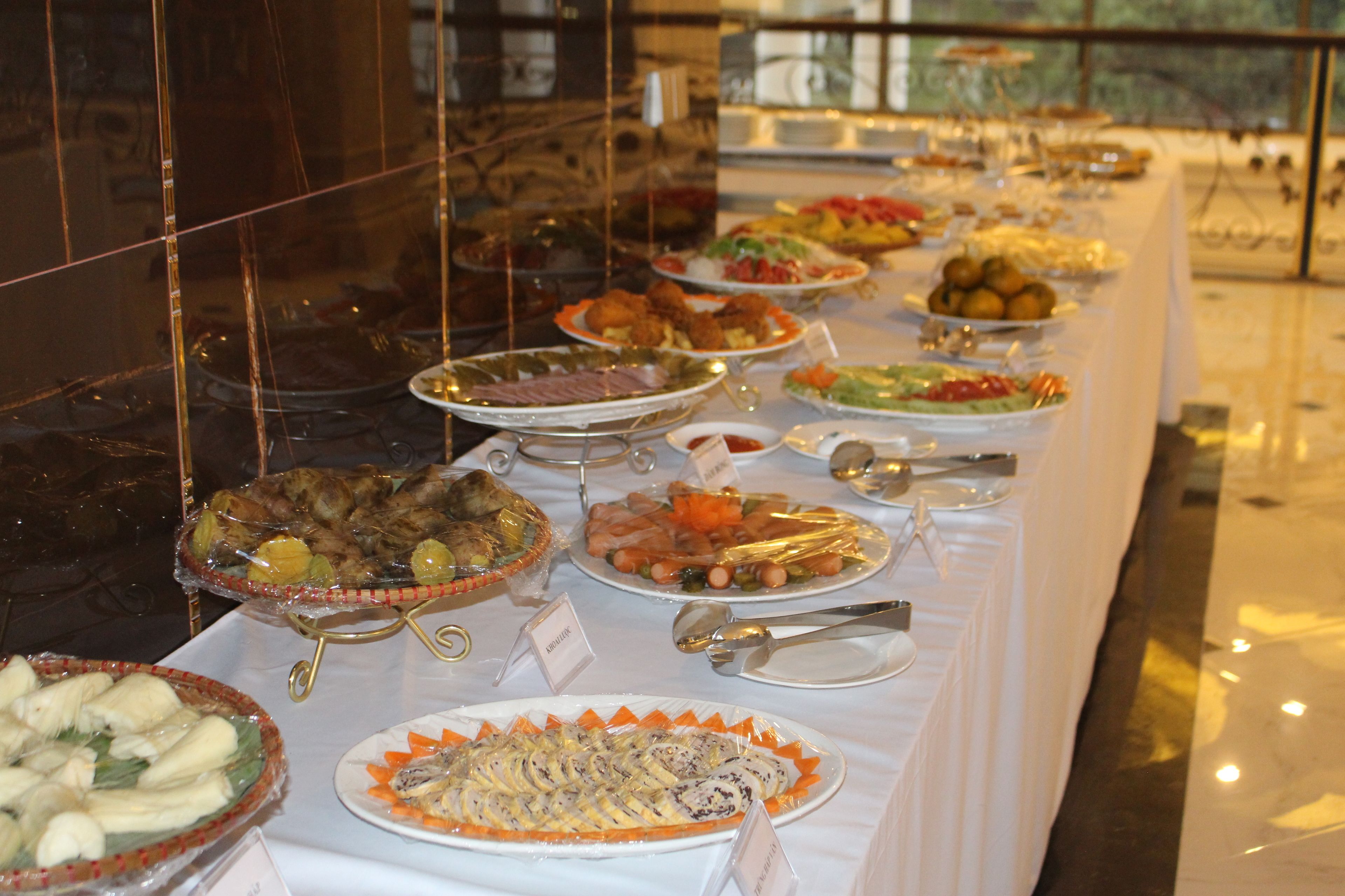 A buffet table with various dishes and utensils.