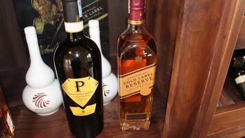 Dos botellas de alcohol sobre una repisa de madera.