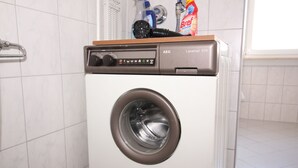 Una lavadora de carga frontal con panel de control y tapa de madera.