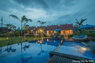 Una piscina al aire libre, sillones reclinables de piscina
