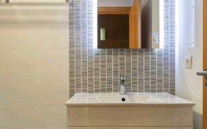 Tina con regadera, secadora de cabello, bidet, toallas