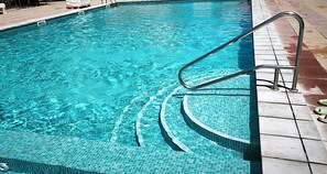 A clear swimming pool with a metal ladder and tiled steps leading into the water. - CALAFELL 5 BEACH WITH: POOL, BEACH, PARKING, SUPERMARKETS / MAC-DONALS (Calafell)