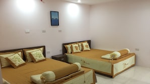 A hotel room with two beds, each with a brown bedspread and matching pillows. There is a small nightstand between the beds, and a framed picture on the wall.