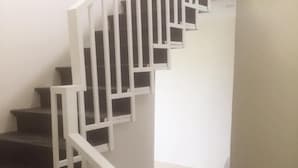A staircase with white railings and dark steps.