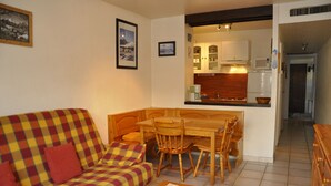 A living room with a sofa, a coffee table, and a dining area with a table and chairs. - T2 rent at the foot of the slopes - Les Deux Alpes - 38m2 + balcony (Les Deux-Alpes)