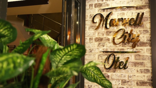 Una pared de ladrillo con el texto "Marvell City Hotel" en letras doradas.