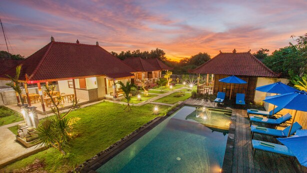 Un resort con piscina, sillas de descanso y un césped bien cuidado.