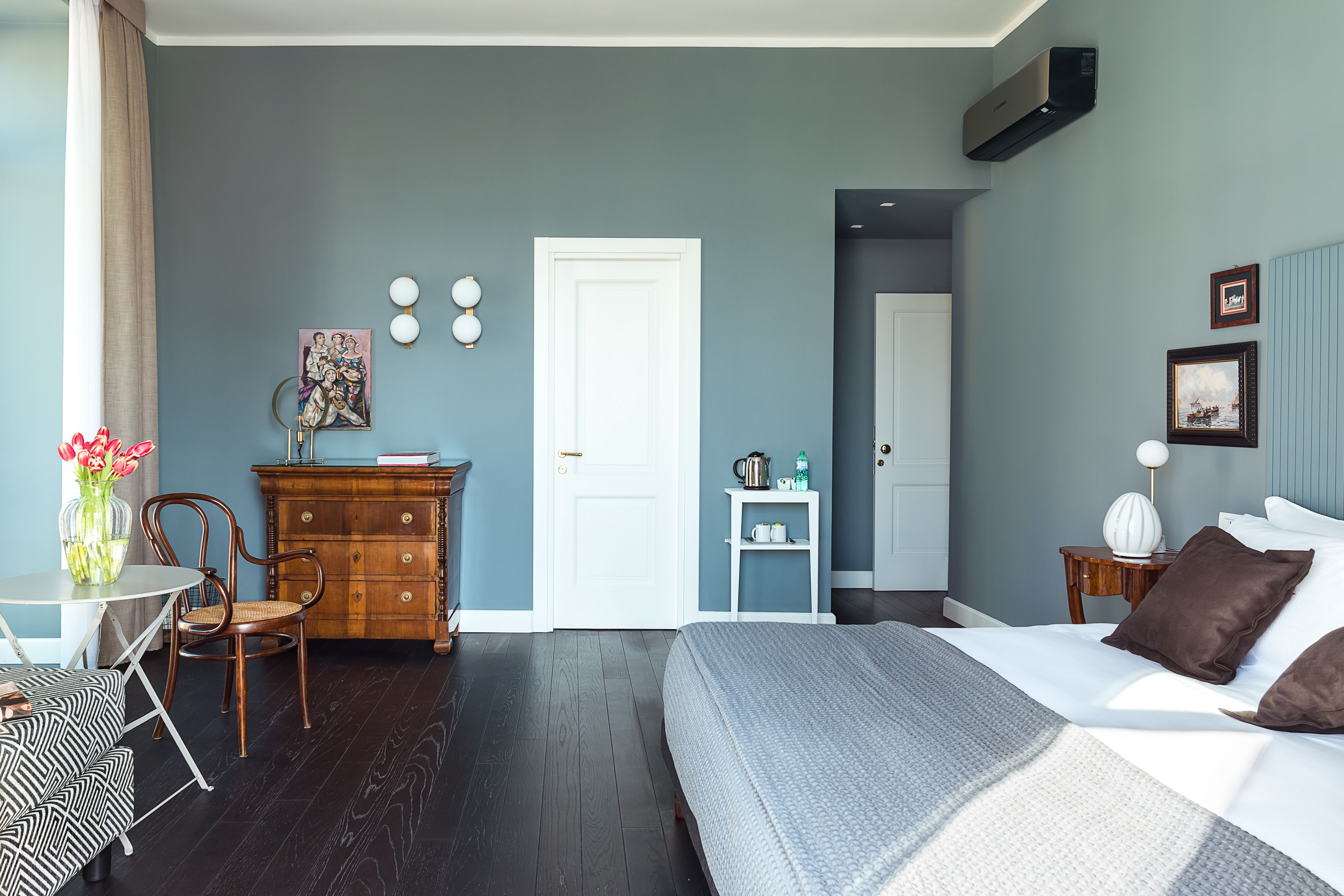Ein Schlafzimmer mit Bett, Kommode und einem kleinen Tisch mit Stühlen.