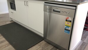 A compact kitchen with a dishwasher, a microwave, and a sink.