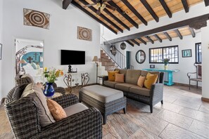 A spacious living room with a high ceiling, a fireplace, and a television.