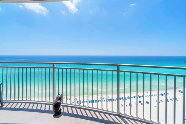 A balcony with a view of a beach and ocean.