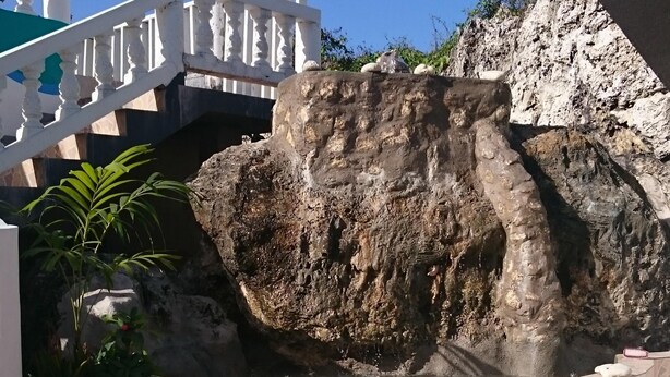 Une fontaine en pierre, dotée d’une balustrade blanche et d’une série de marches menant à son sommet.