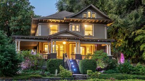 A two-story house with a porch, a staircase, and a well-maintained garden. - Inn at the Gorge (Hood River)