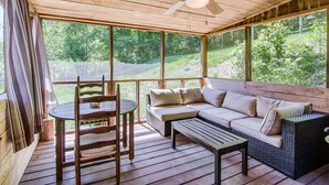 Una terraza de madera con un sofá, una mesa y sillas.