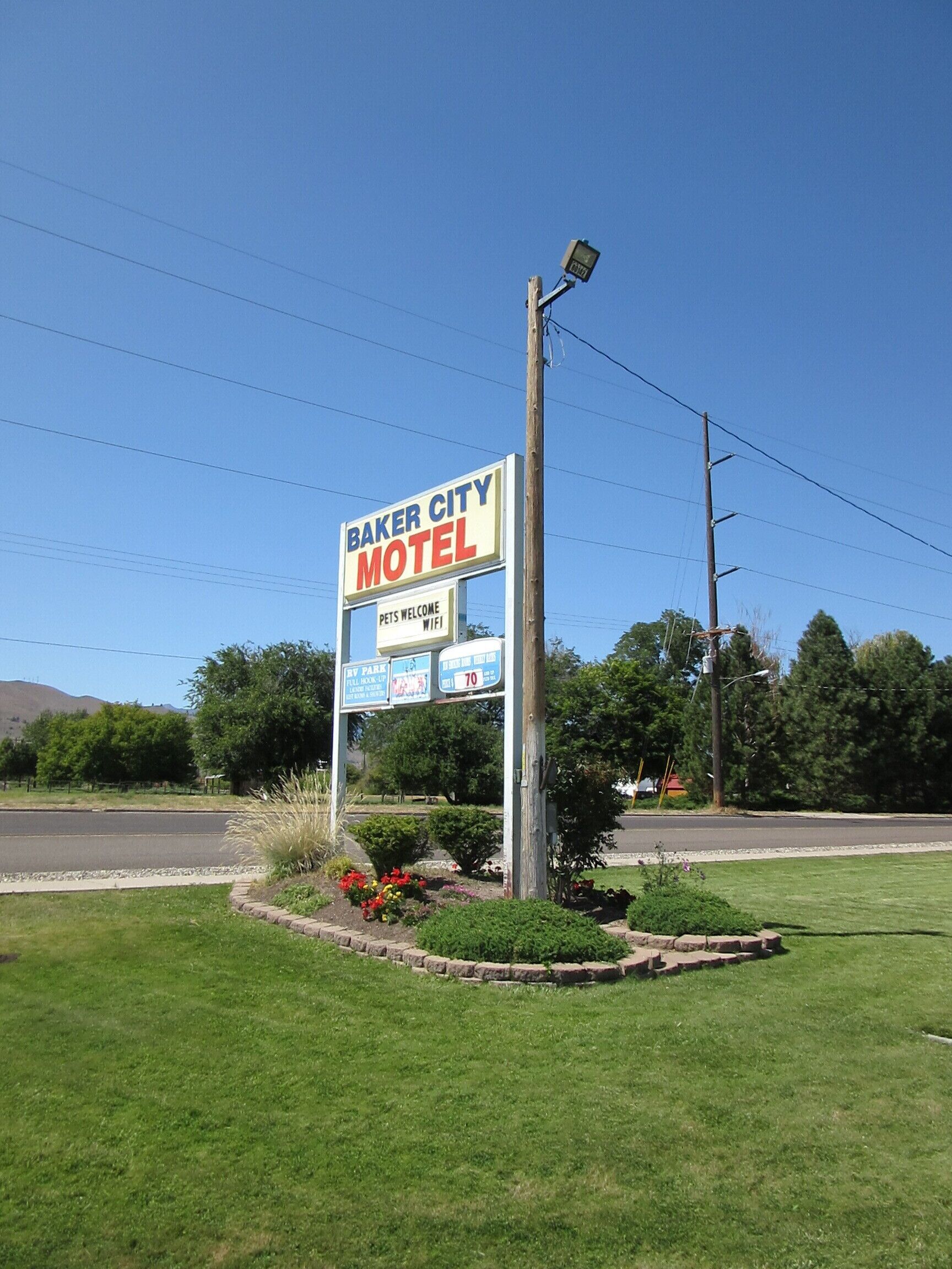 A motel sign with a clear view of the name 'Baker City Motel' and additional information including 'Pets Welcome' and 'WiFi'.
