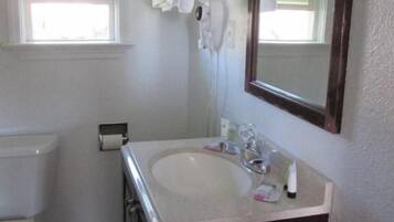 A bathroom with a toilet, sink, and towel rack.