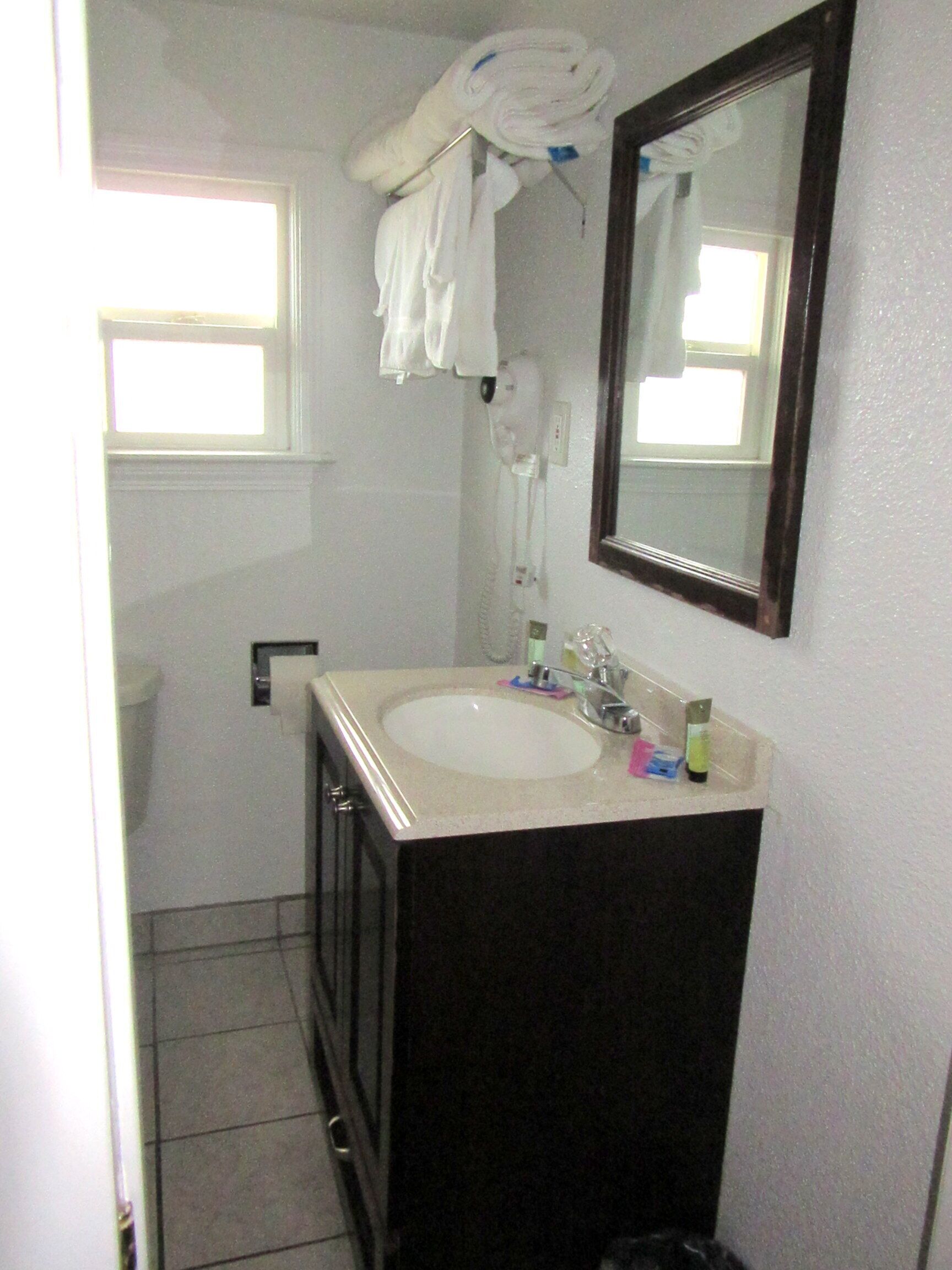 Une petite salle de bain avec un lavabo, un miroir et un porte-serviettes.