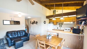 Un espacio habitable funcional con sofá, mesa de comedor y zona de cocina.