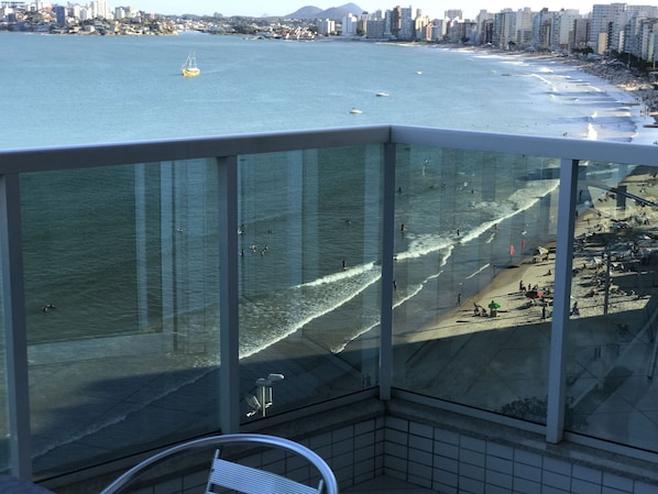 Un balcon avec vue sur une plage et l’océan.