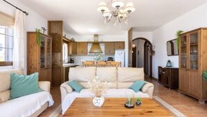 A cozy living room with a sofa, a wooden coffee table, and a chandelier. - Home2Book Garachico Ocean View & Wifi (Las Cruces)