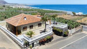 A coastal property with a tiled roof, a balcony, and a view of the sea. - Home2Book Garachico Ocean View & Wifi (Las Cruces)
