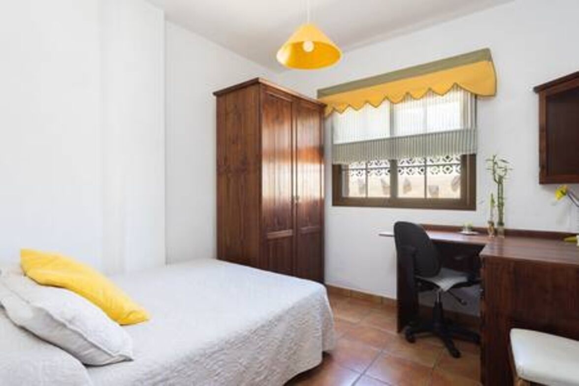 Una camera da letto con un letto, una scrivania e una sedia.