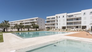 Ein modernes Hotel mit Schwimmbad, mehreren Balkonen und Lounges.