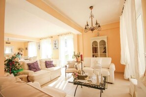 Un salon comprenant un canapé, une table basse et un lustre.