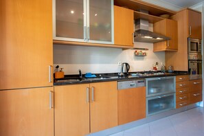 Une cuisine moderne avec des meubles en bois, un lave-vaisselle Bosch, un four et un four à micro-ondes.